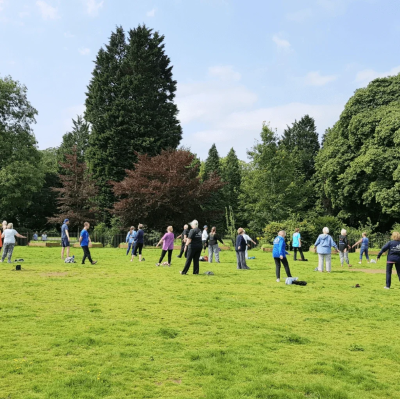 A group of people undertaking Tai Chi in a park