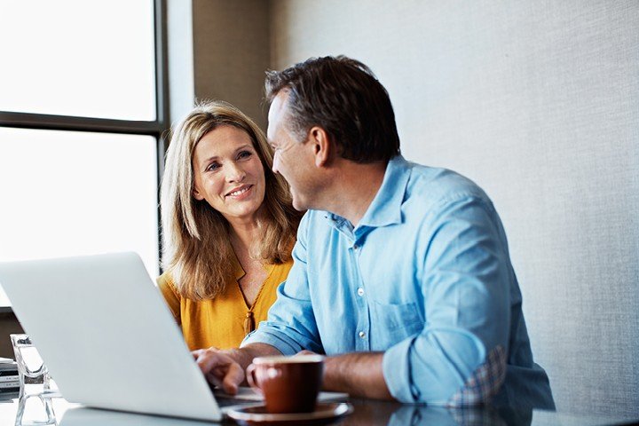 Couple sit in their kitchen after speaking to an adviser from Mortgage Advice Bureau about a buy to let mortgage