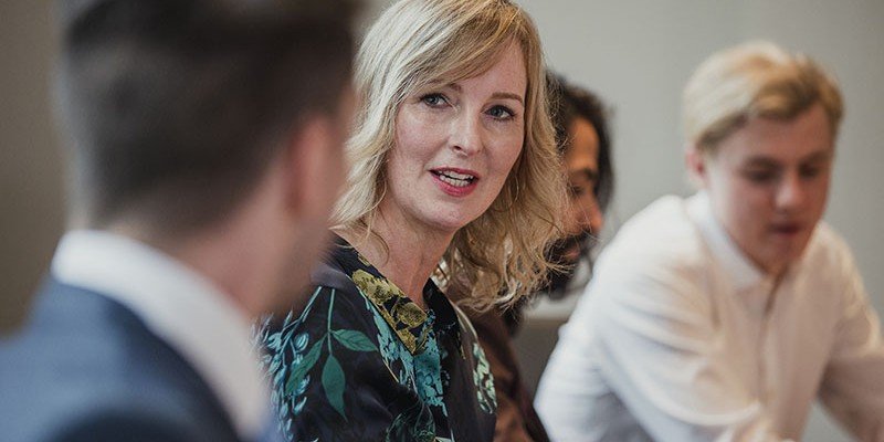 Woman sat at a table with colleagues