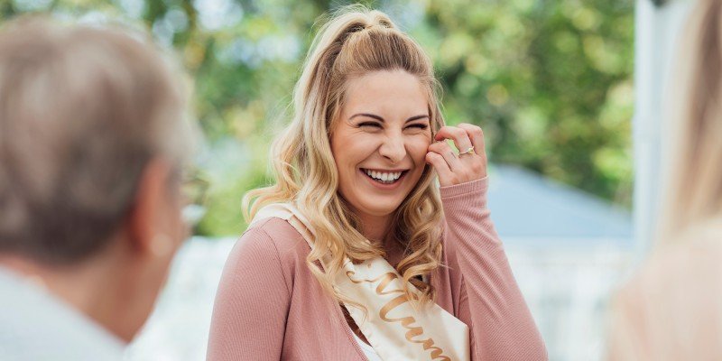 Mum-to-be smiles at her baby shower having saved for her child using her ISA allowance.